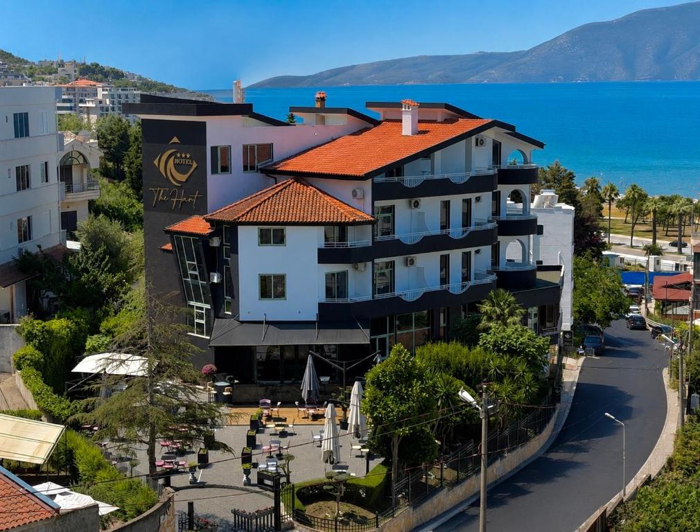 a building on the side of a street next to the water at The Hart in Vlorë