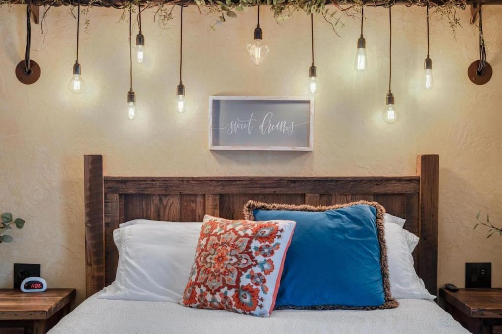a bedroom with a bed with a wooden headboard and lights at The Rustic Suite with Hot Tub Romantic Getaway on Main Street in Berlin