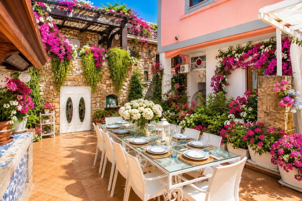 a long table in a garden with flowers at Maison Vico94 in Vico Equense