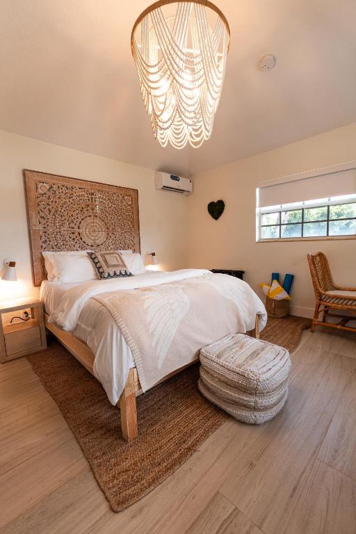 a bedroom with a large bed and a chandelier at Seahorse Beach Bungalows in Fort Pierce