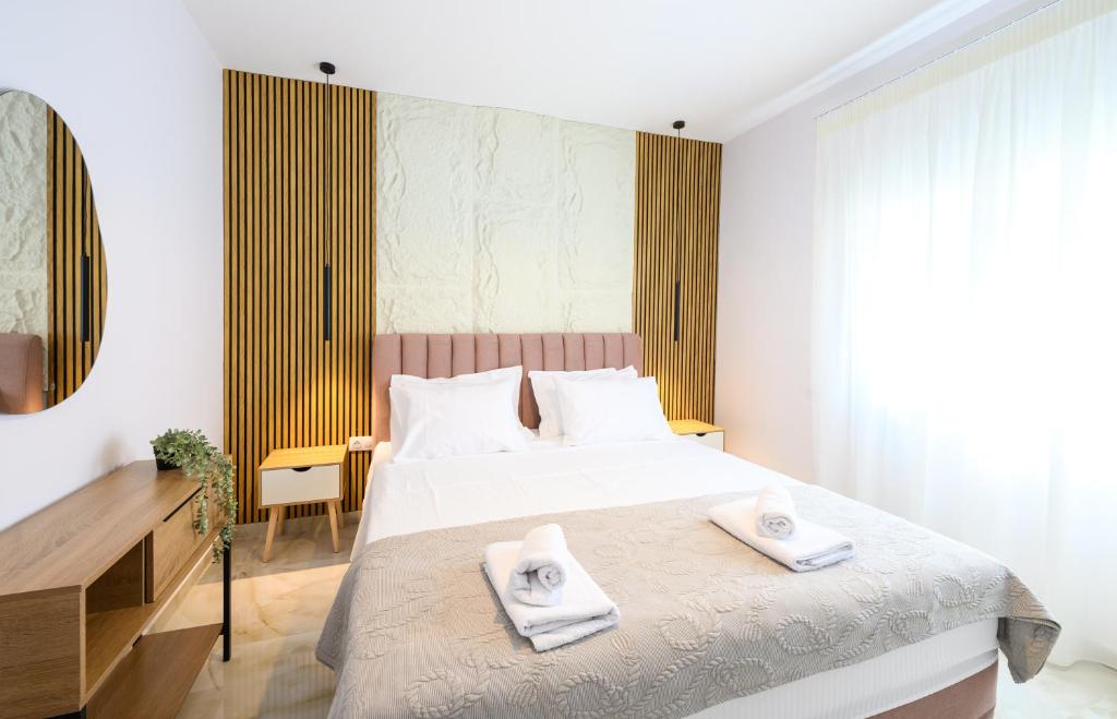 a bedroom with a bed with two towels on it at Korina Suites in Perea