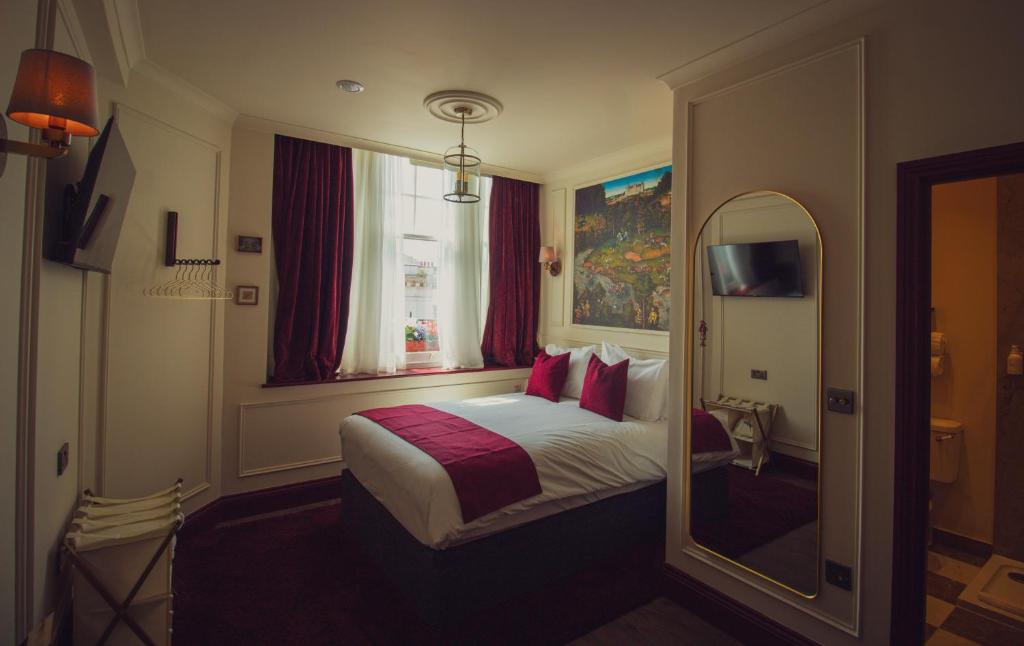 a hotel room with a bed and a mirror at The Goat in Boots in London