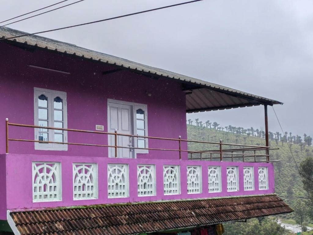 a purple house with a balcony on top of it at S K S HOME STAYs in Vālpārai