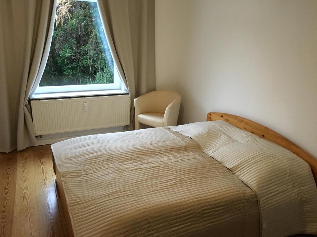 1 dormitorio con 1 cama, 1 silla y 1 ventana en All you need - Room, en Hamburgo