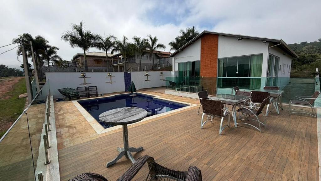 a patio with a pool and a table and chairs at Refúgio com Piscina e Vista Deslumbrante in Caconde