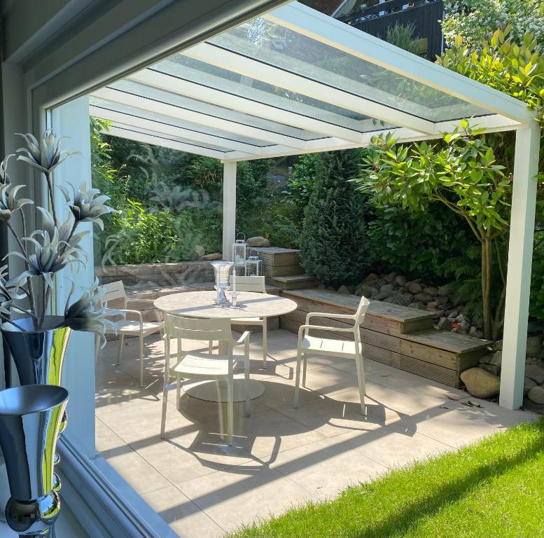 a patio with a table and chairs under a pergola at Ferienwohnung Edelweiss am Steinberg in Goslar mit Terrasse und Garage in Goslar