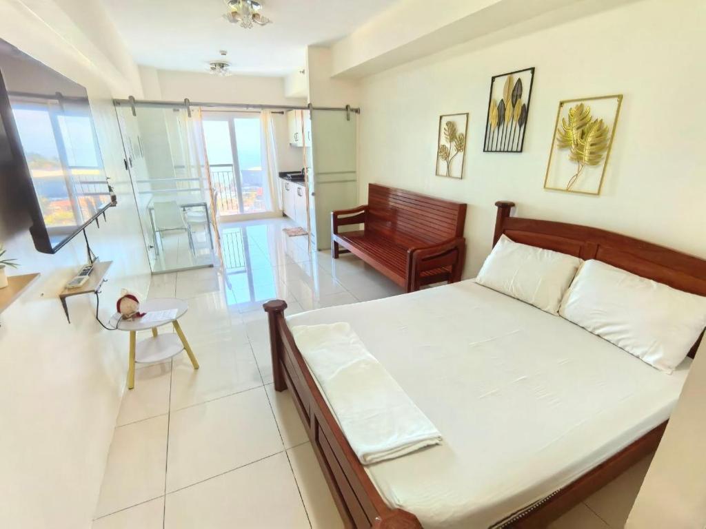 a bedroom with a bed and a living room at SMDC Wind Residences Condo Unit by Bil & J's in Kaybagal