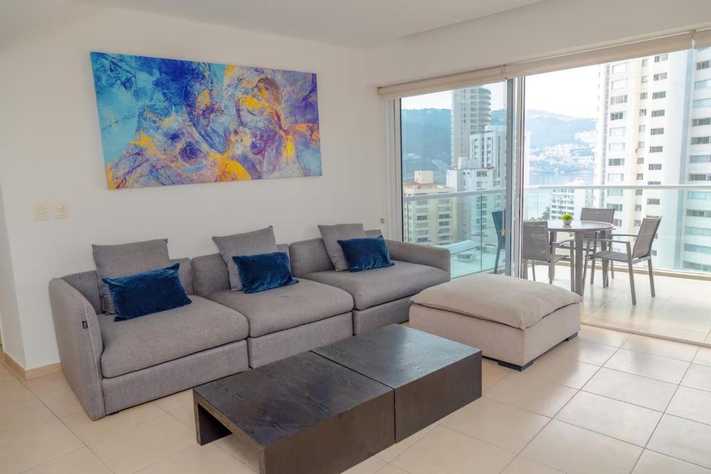 a living room with a couch and a table at Ocean View Condo with Resort Amenities in Acapulco