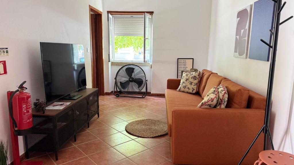 a living room with a couch and a flat screen tv at Habita Avenida 9 Abril in Estremoz