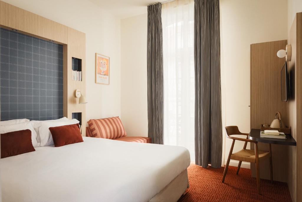 a hotel room with a large bed and a desk at Marnie House in Le Touquet-Paris-Plage