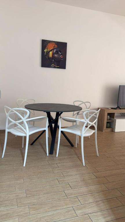 a table and chairs with a table and a painting at Casa della nonna in Pescara