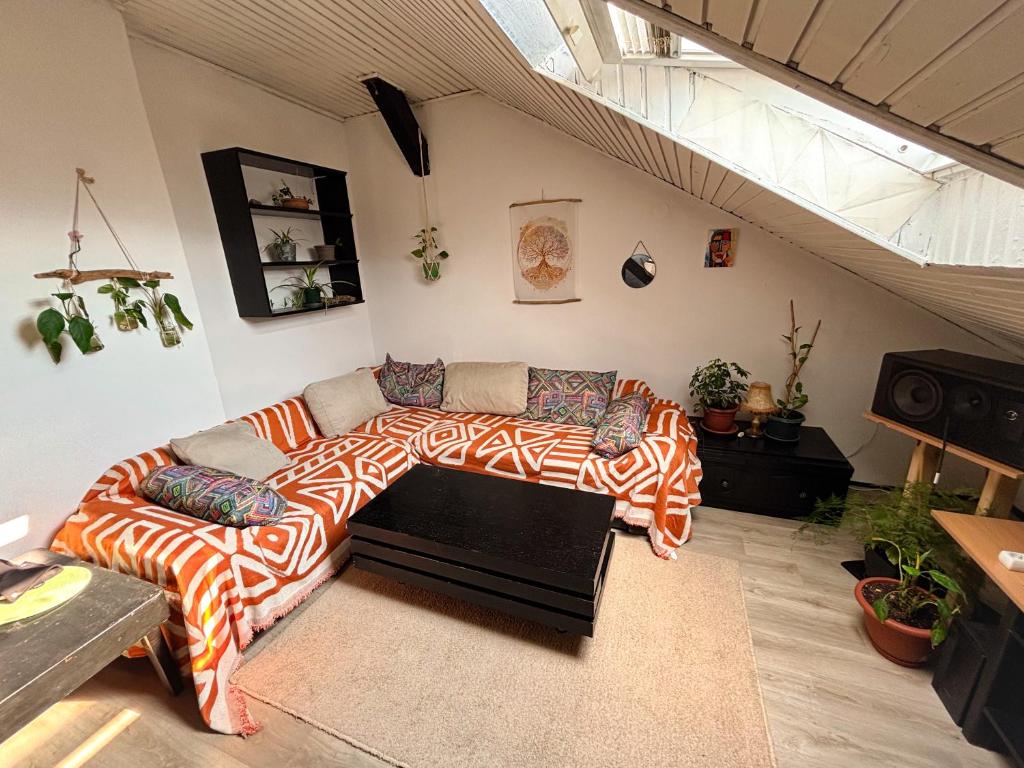 a living room with a sectional couch with a blanket at The Vibe Spot in Podgorica