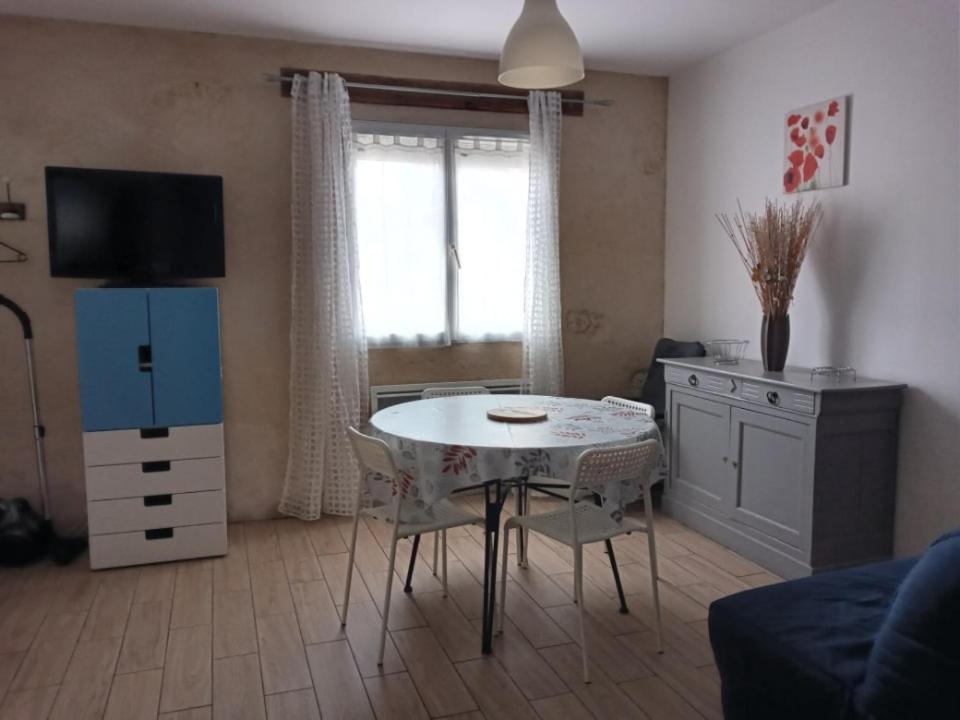 a living room with a table with chairs and a tv at Studio à louer in Vic-Fezensac