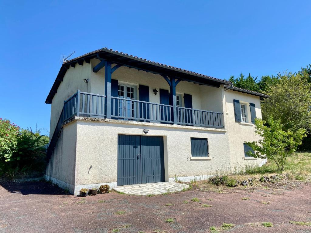 a white house with a balcony on top of it at La Rousselie in Montagrier