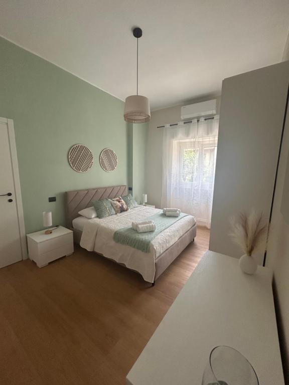 a white bedroom with a bed and a window at Maris Home in Luino