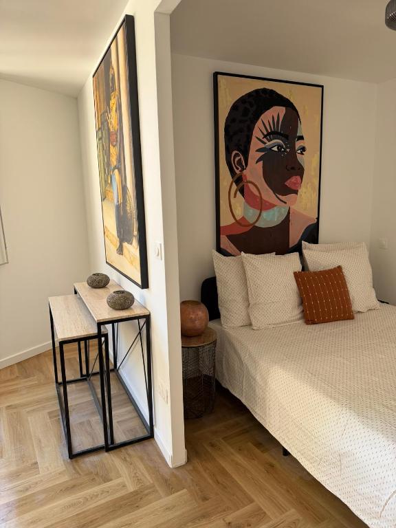 a bedroom with a bed and a painting on the wall at Heritage Suites- Palais des Papes & Pont d'Avignon- Clim in Avignon