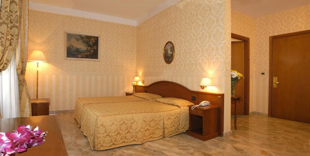 um quarto de hotel com uma cama e uma mesa em Hotel Orazia em Roma