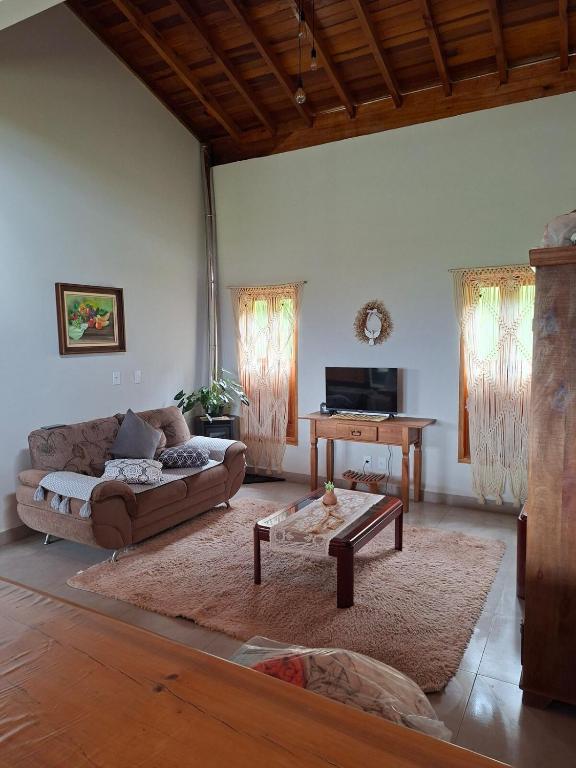 a living room with a couch and a table at Chalé Araucárias-Recanto dos pássaros in Cambuí