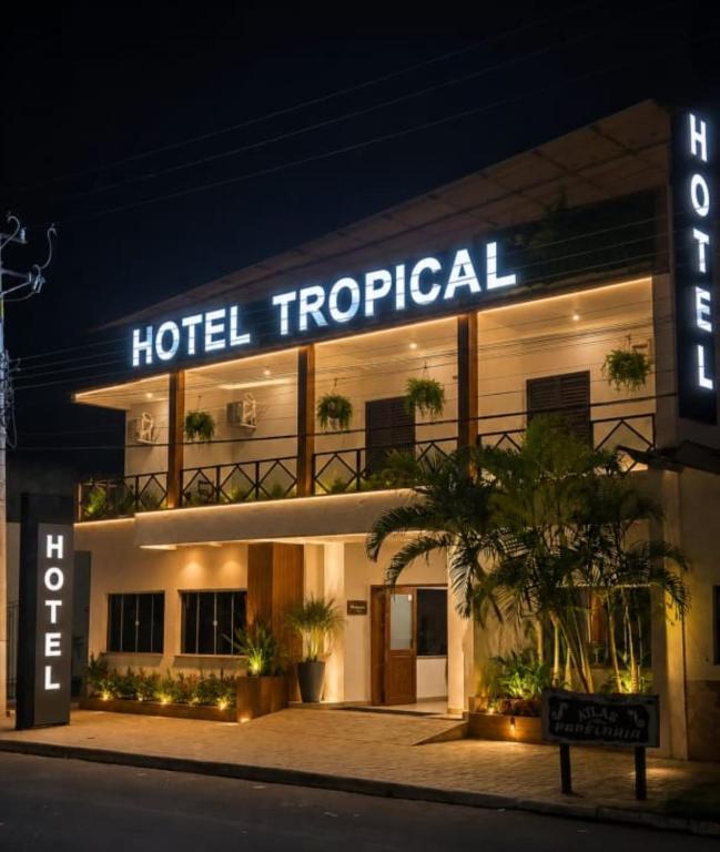 a hotel tropical is lit up at night at HOTEL TROPICAL in Jardim