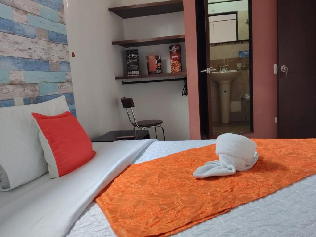 a stuffed animal is sitting on a bed at Hotel estación Kristal - Corferias in Bogotá