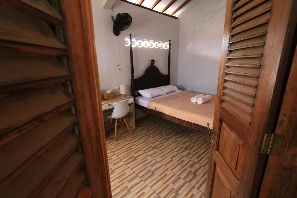 a small bedroom with a bed and a desk at Gemyah in Banyuwangi