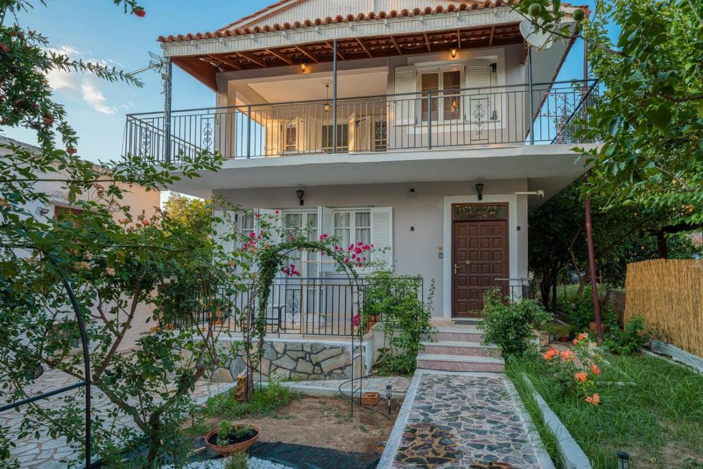 a white house with a balcony and a door at Villa Amalia Laconia in Dháfnion