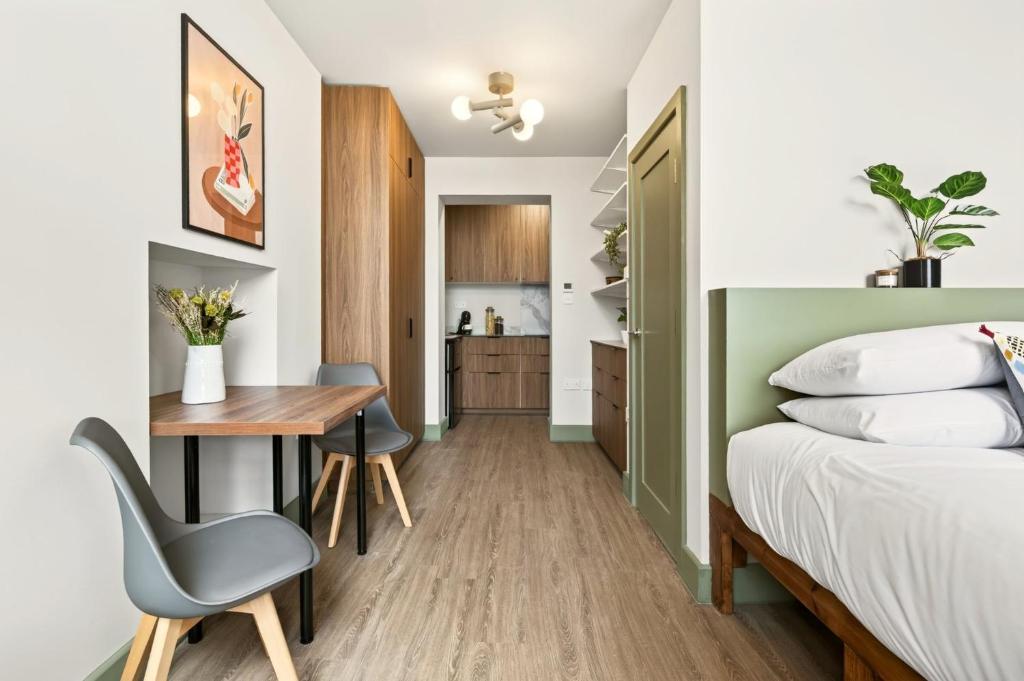 a bedroom with a bed and a desk and a table at GuestReady - The Bridge - Wealdstone in London