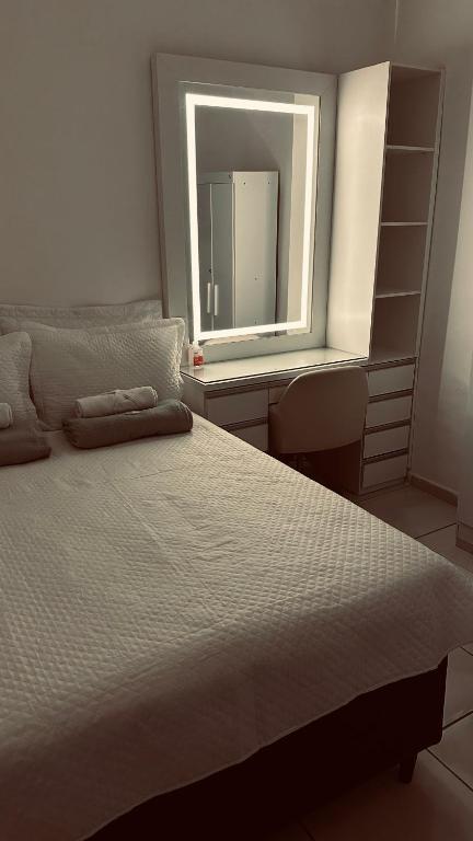 a bedroom with a large bed and a mirror at Quarto privativo com penteadeira LED - n 326A in Petrolina