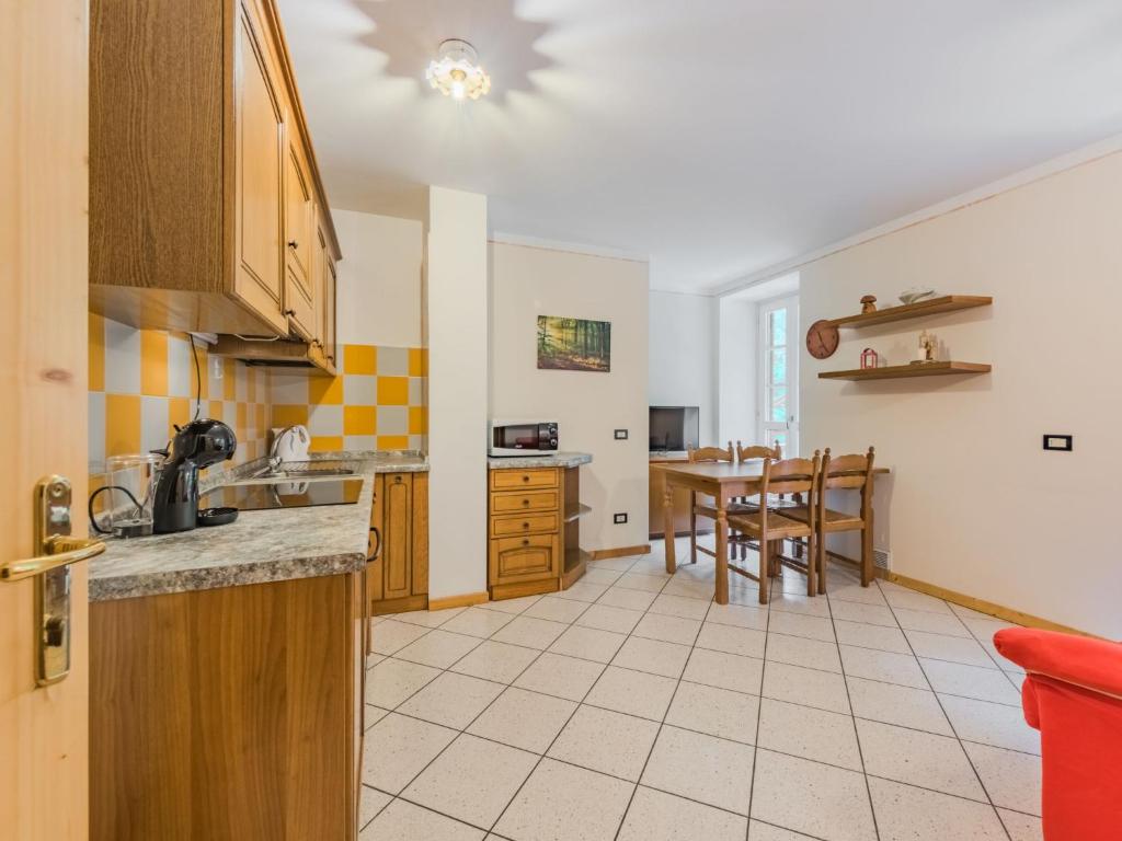 a kitchen with a table and a dining room at Apartment Abete e Betulla by Interhome in Rabbi