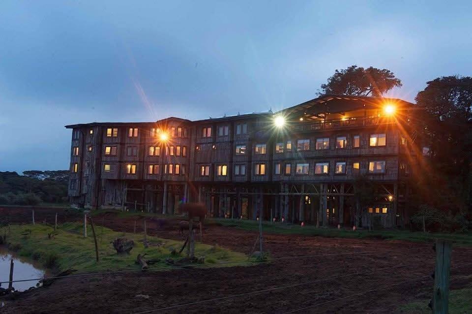a large building with two street lights in front of it at The Treetops Lodge in Nyeri