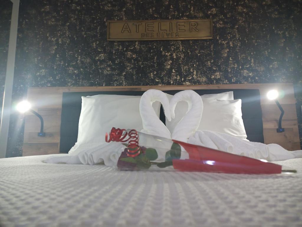 a bed with two swans made out of towels at Love Room Emoi de toi in Sigean