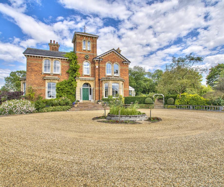 a large brick building with a clock tower on it at Milton House Group Retreats in Bedford
