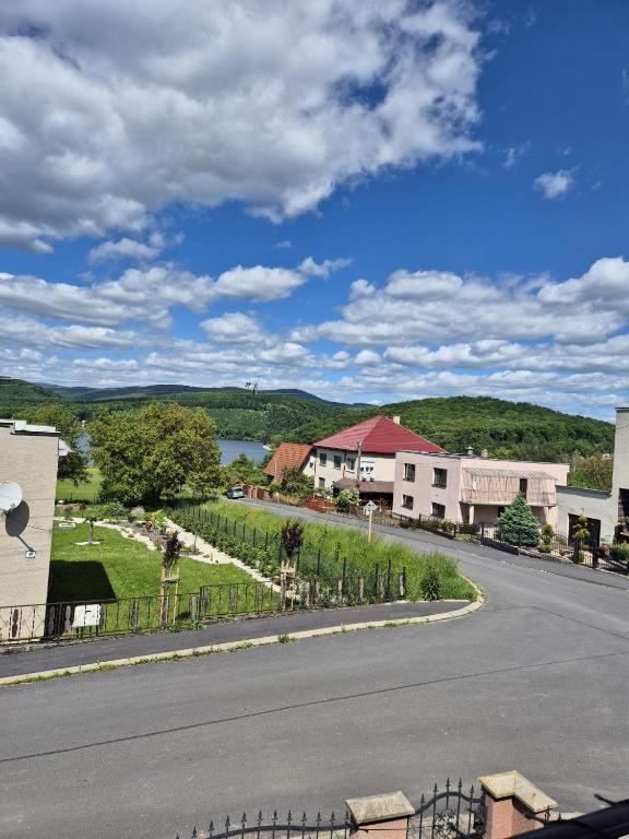 an empty street in a town with buildings and a lake at Apartmán Ružiná in Ružiná