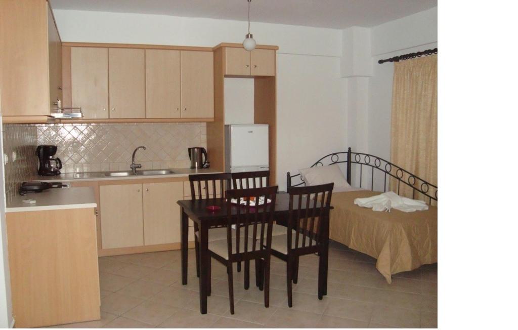 a kitchen with a table and chairs and a bed at Kratounis Apartment 2 in Oikonomiánika