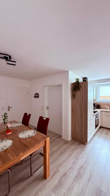 a living room with a wooden table and a kitchen at Ferienwohnung im Ellertal in Bockelnhagen