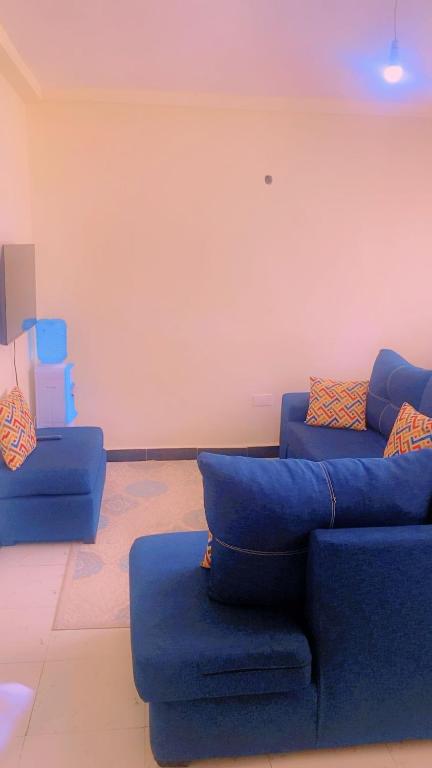 a living room with two blue couches in a room at Moh airbnbs in Kisumu
