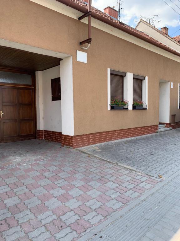 a house with two windows and a door and flowers at Ubytování Adina in Velké Pavlovice