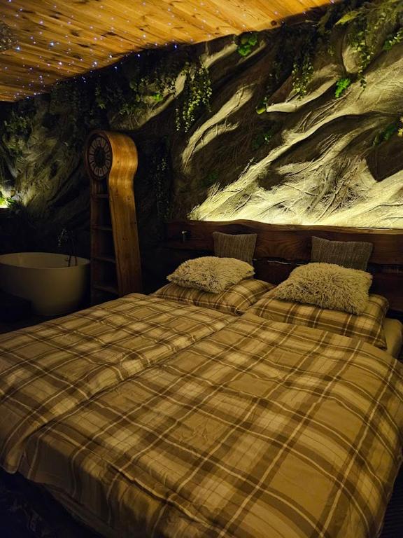 a bedroom with a bed with a painting on the wall at Chatka Bystrá jacuzzi,stars,river in Bystrá