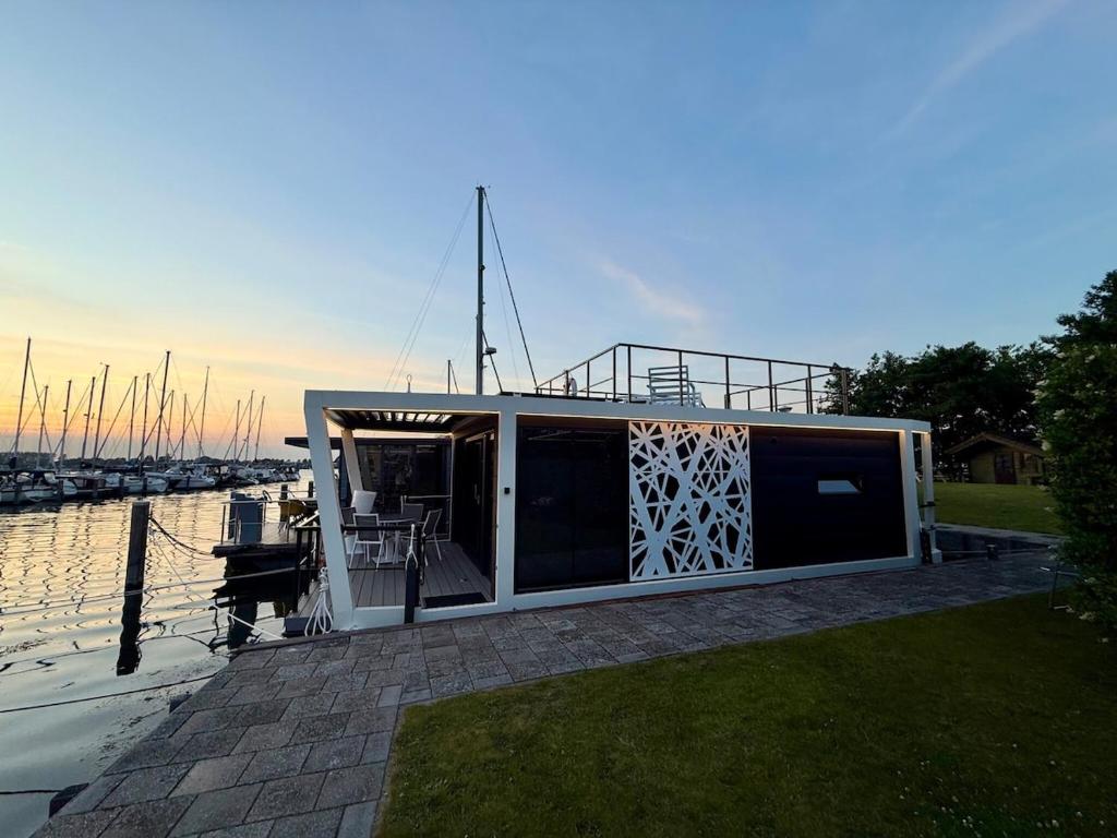a small boat with a deck on the water at Luxury Houseboat Wolphaartsdijk VP109 in Wolphaartsdijk