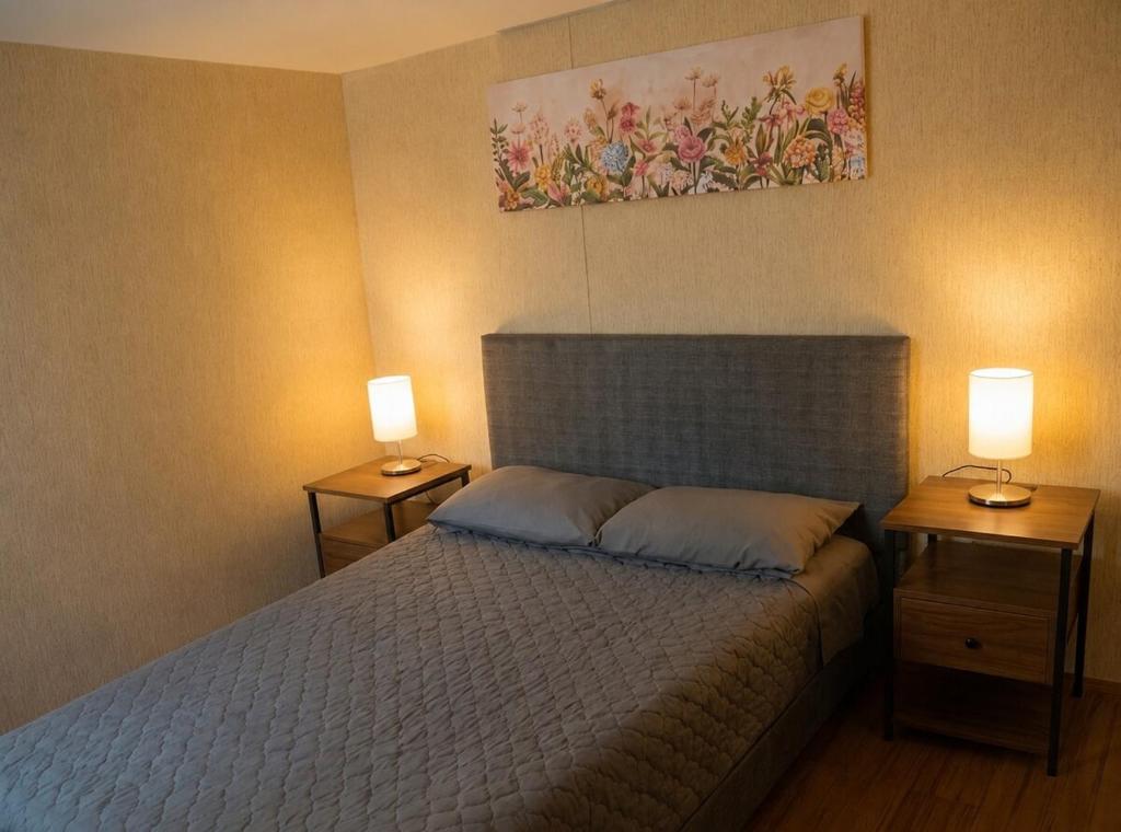 a bedroom with a bed with two lamps on both sides at Cesar's Apartment - Los Laureles in Lima