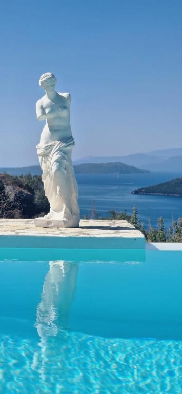 a statue sitting next to a swimming pool at Villa Magiko in Poros