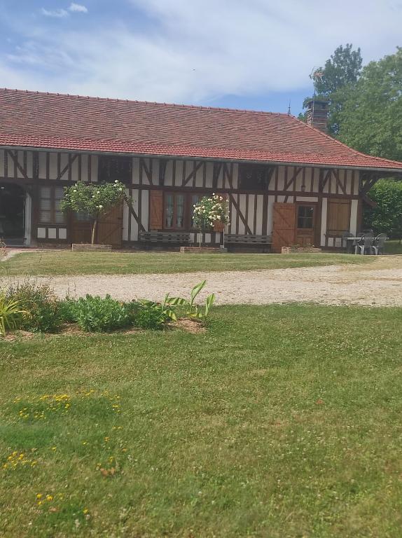 a building with a green yard in front of it at Les Rosiers in Onjon