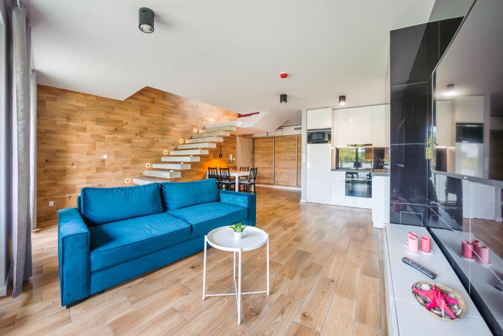 a living room with a blue couch and a kitchen at Jantar Park in Jantar