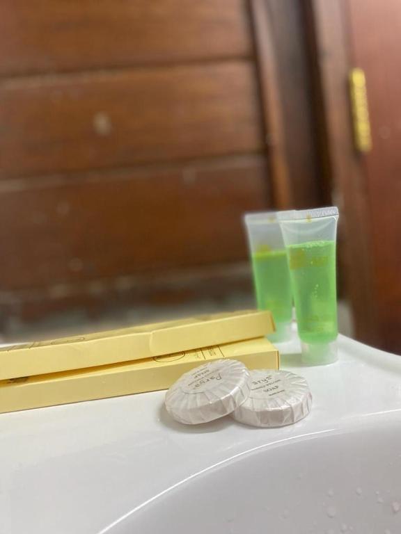a white table with twocoins and a cup of green liquid at شالية الكوخ in Salalah