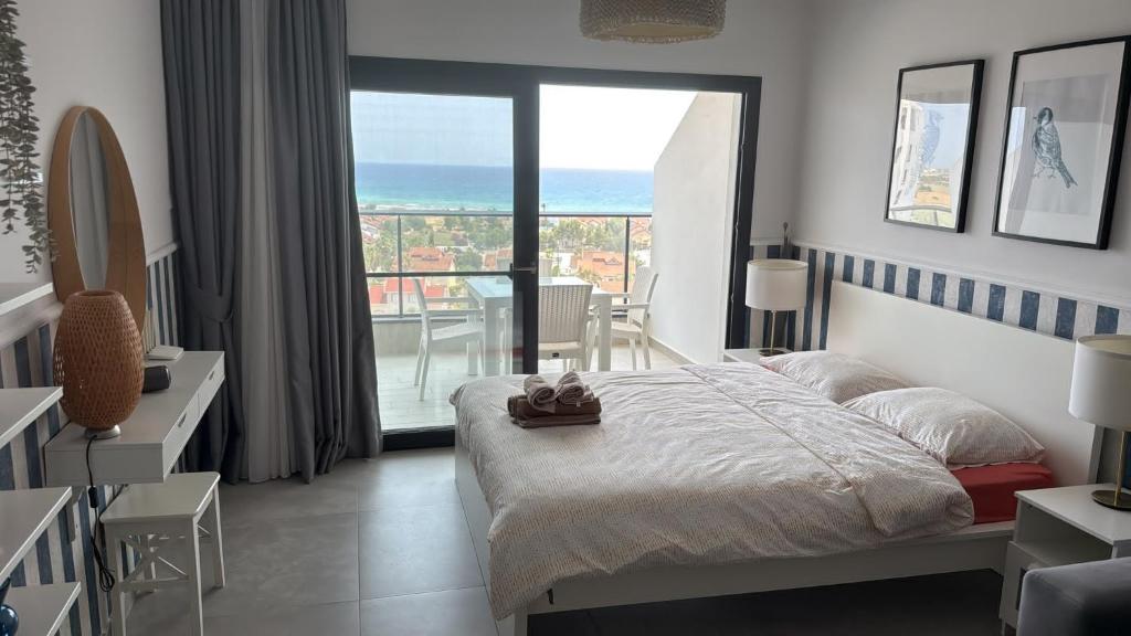 a bedroom with a bed and a view of the ocean at Caesar Blue Studio Sea View Apartment in Boghaz