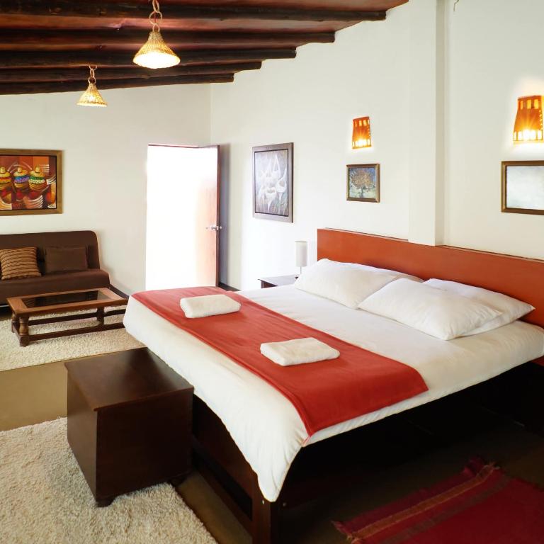 ein Schlafzimmer mit einem großen Bett mit rotem Kopfteil in der Unterkunft Hotel Pilancones in Cajamarca
