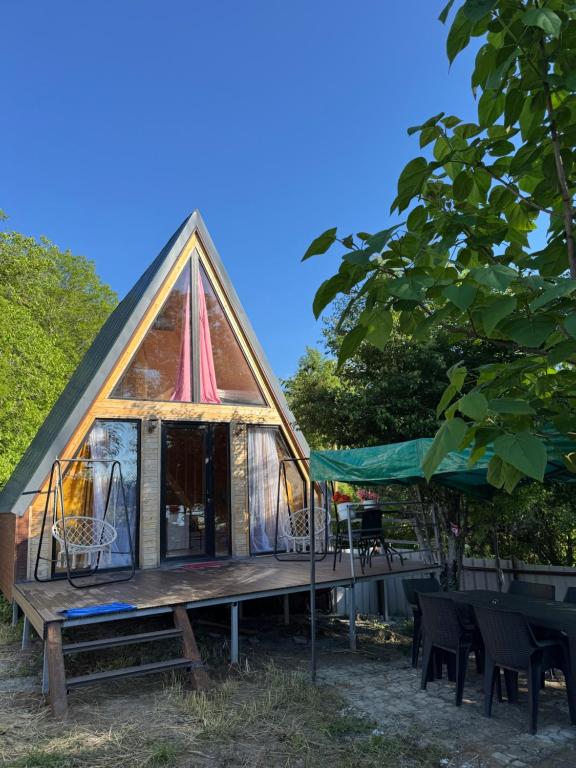 a tiny house with a deck and a tent at Tlughi cottage in Obcha