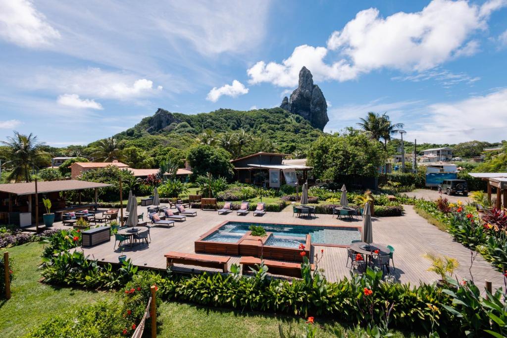a resort with a pool and a mountain in the background at Pousada Moana in Fernando de Noronha
