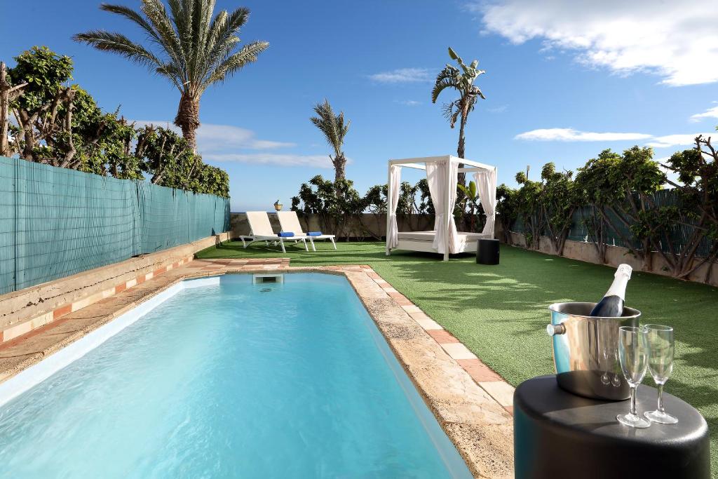 a pool with a gazebo and palm trees at Villas Eurostars Las Salinas in Caleta De Fuste