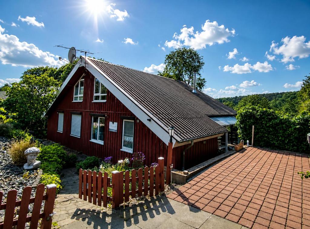 a red house with a fence in front of it at Haus Waldblick in Extertal
